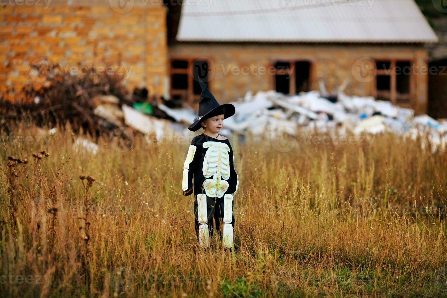 Little boy wearing a skeleton costume and a black hat . Halloween holiday. photo