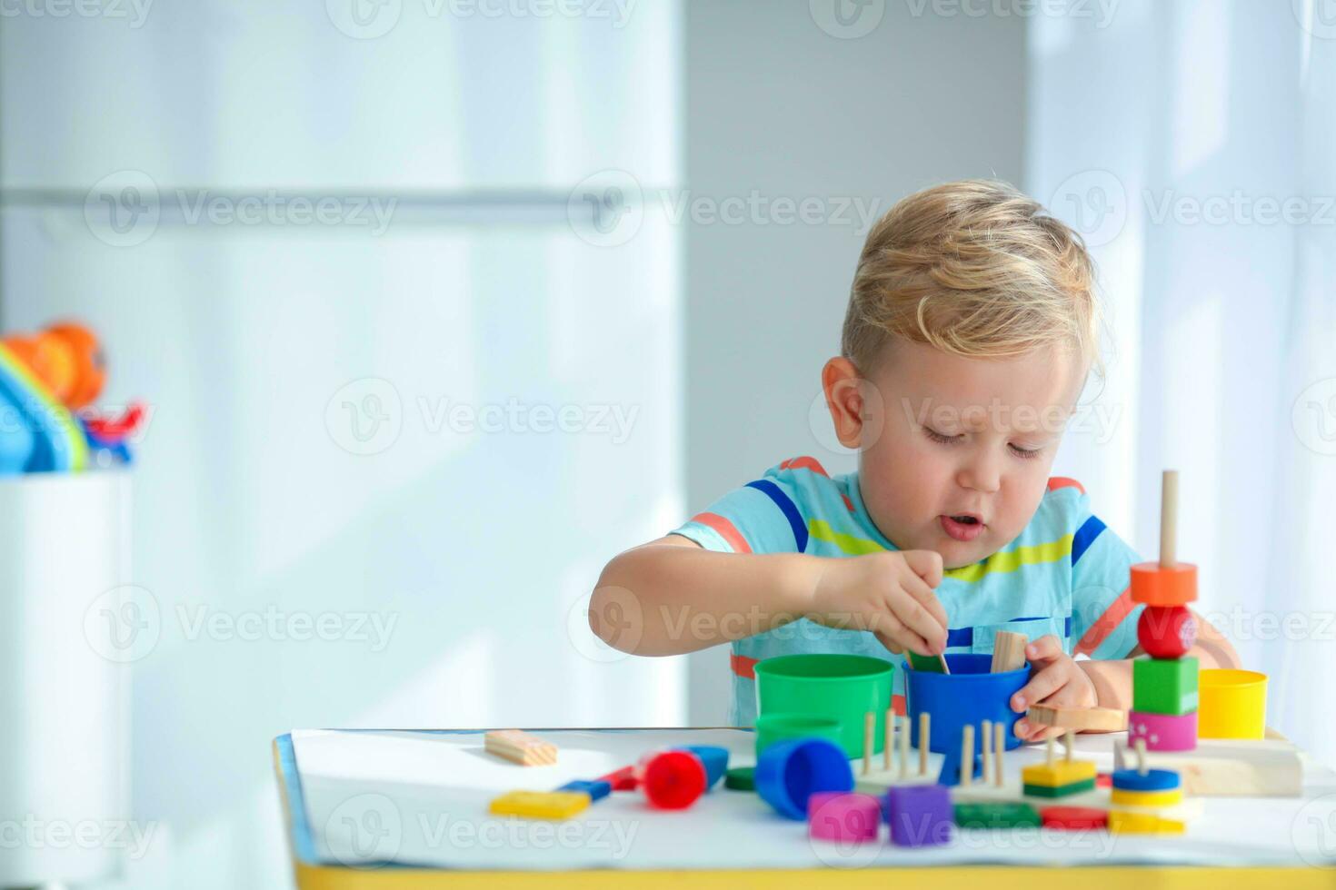 Little boy 2 years old is played with a colors toys. Educational logic toys for children. Montessori games for child development. photo