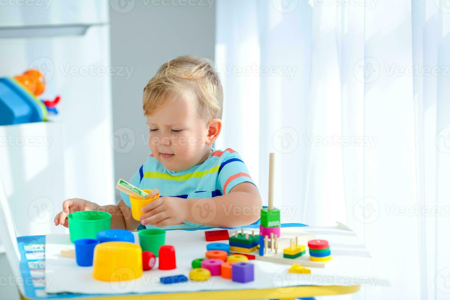 Little boy 2 years old is played with a colors toys. Educational logic toys for children. Montessori games for child development. photo