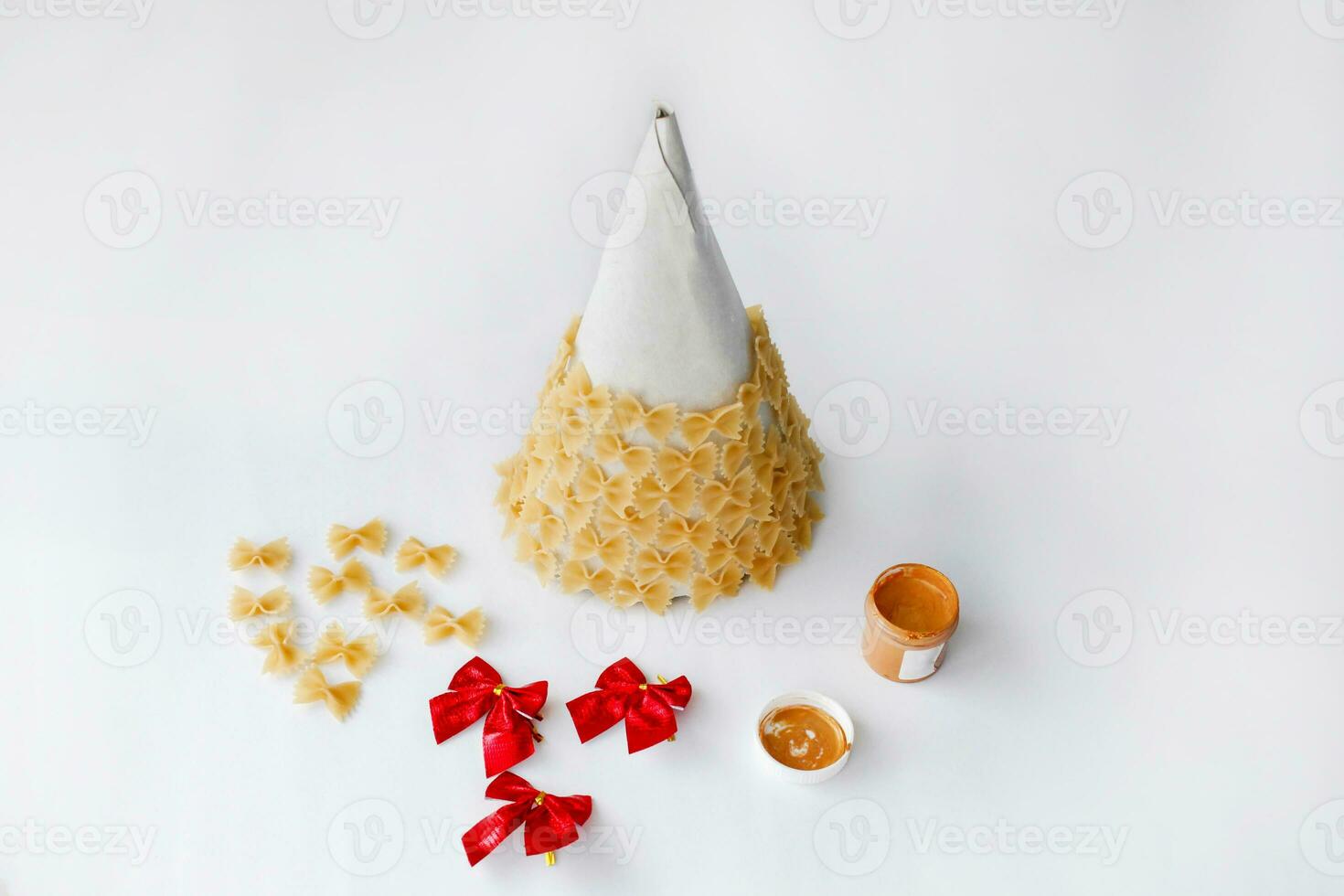 The process of making Christmas trees from pasta,  hot glue and paint or spray. Guide, step by step on the photo.  DIY. Step by step instructions for crafts for the new year. Step 2 . photo