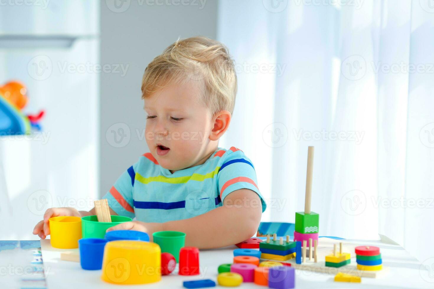 Little boy 2 years old is played with a colors toys. Educational logic toys for children. Montessori games for child development. photo