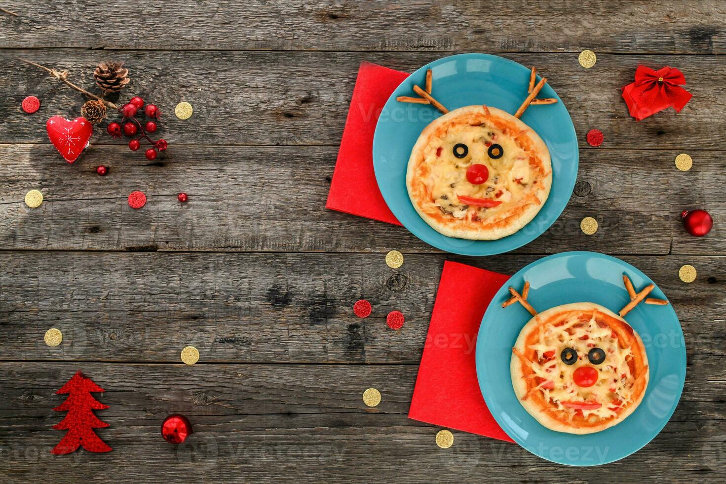Two Christmas small pizza in a shape of reindeer on a wooden background. Copy space. photo