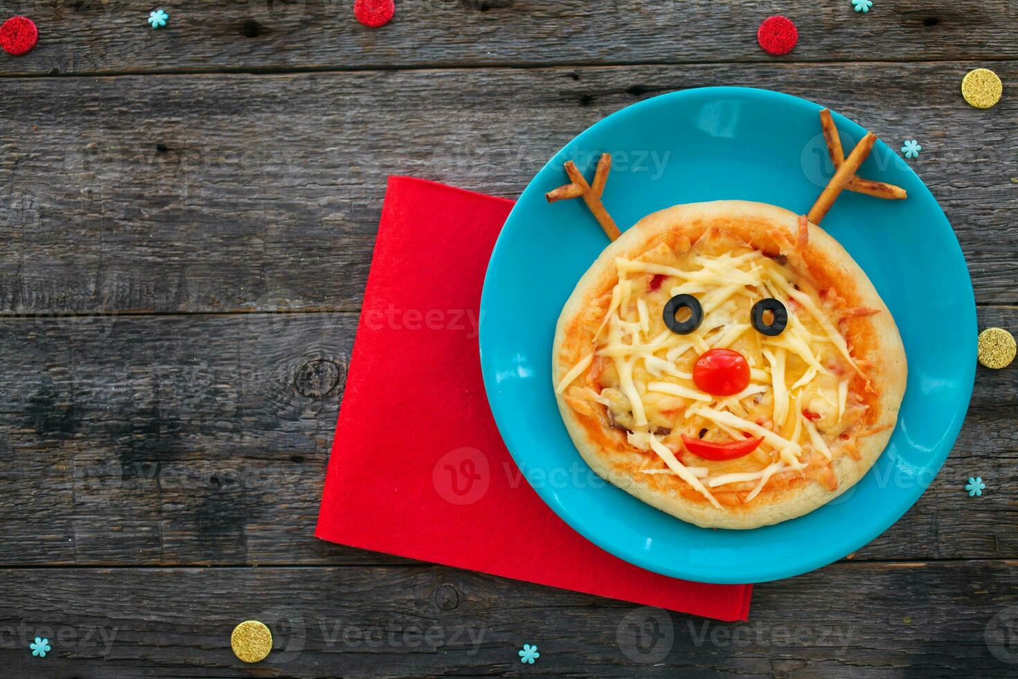 Christmas pizza in a shape of reindeer on a wooden background. Copy space. photo