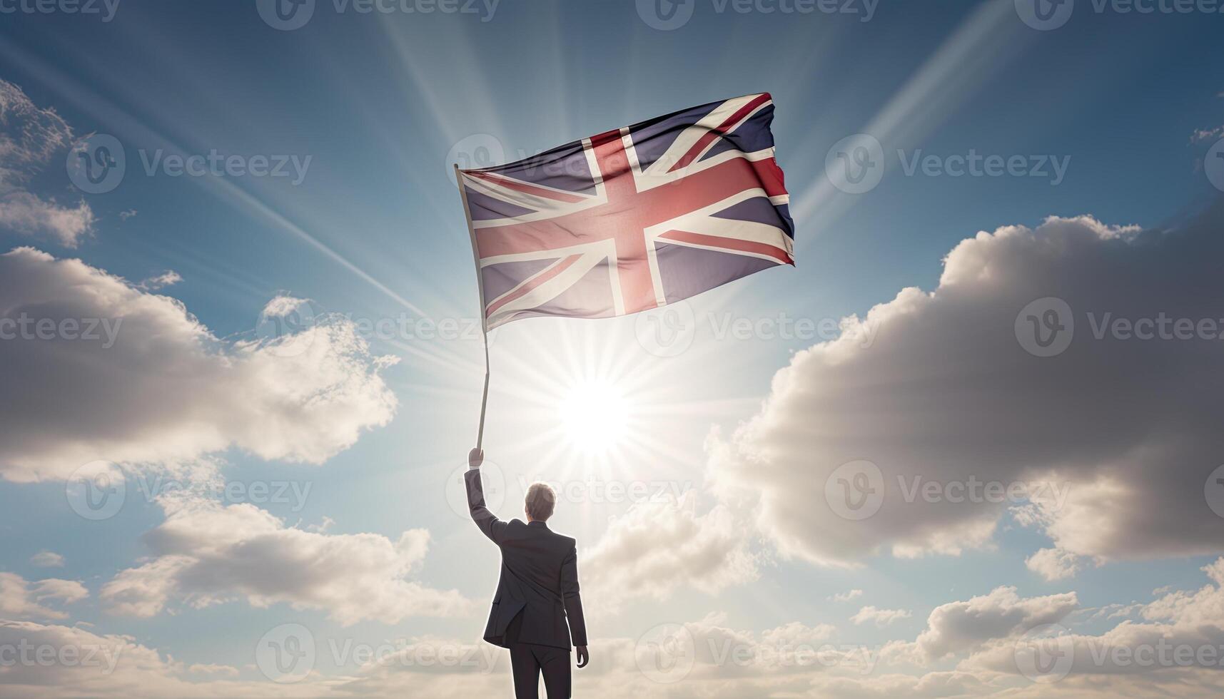 Businessman holding uk flag against blue sky with sunbeams. . photo