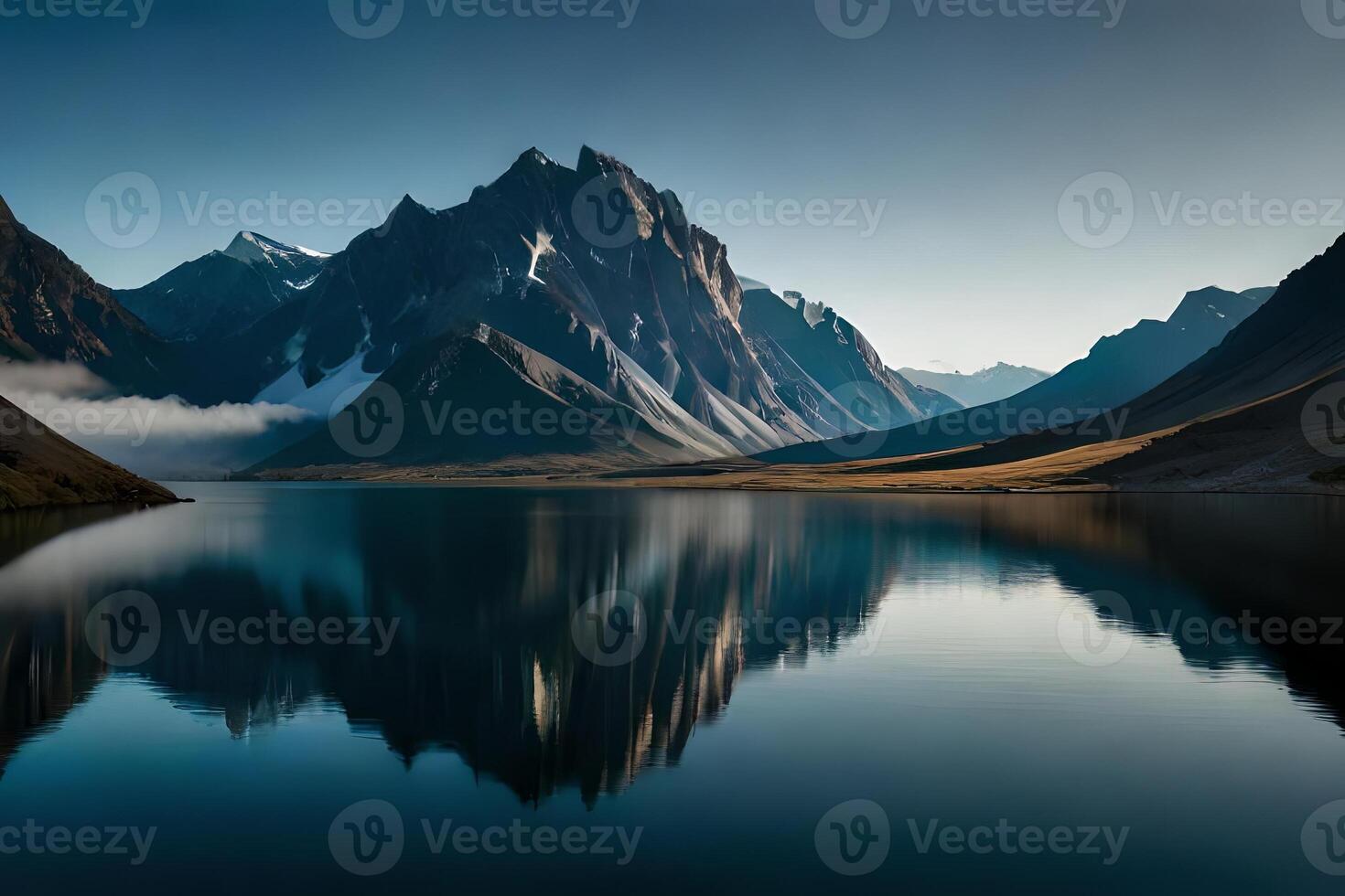 A calm lake reflecting the brilliant mountain peaks that cement it. photo