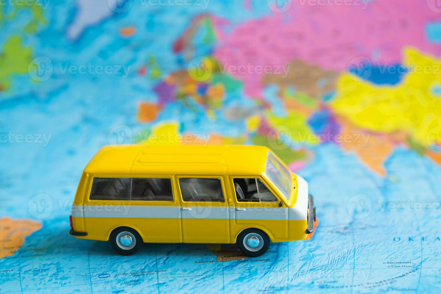 Yellow bus on satin. World map, close-up photo