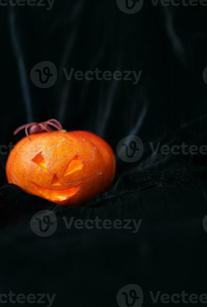 October 31, Halloween - Old Jack-o-Lantern on a black background. The spider sits on a pumpkin. Place for an inscription. photo