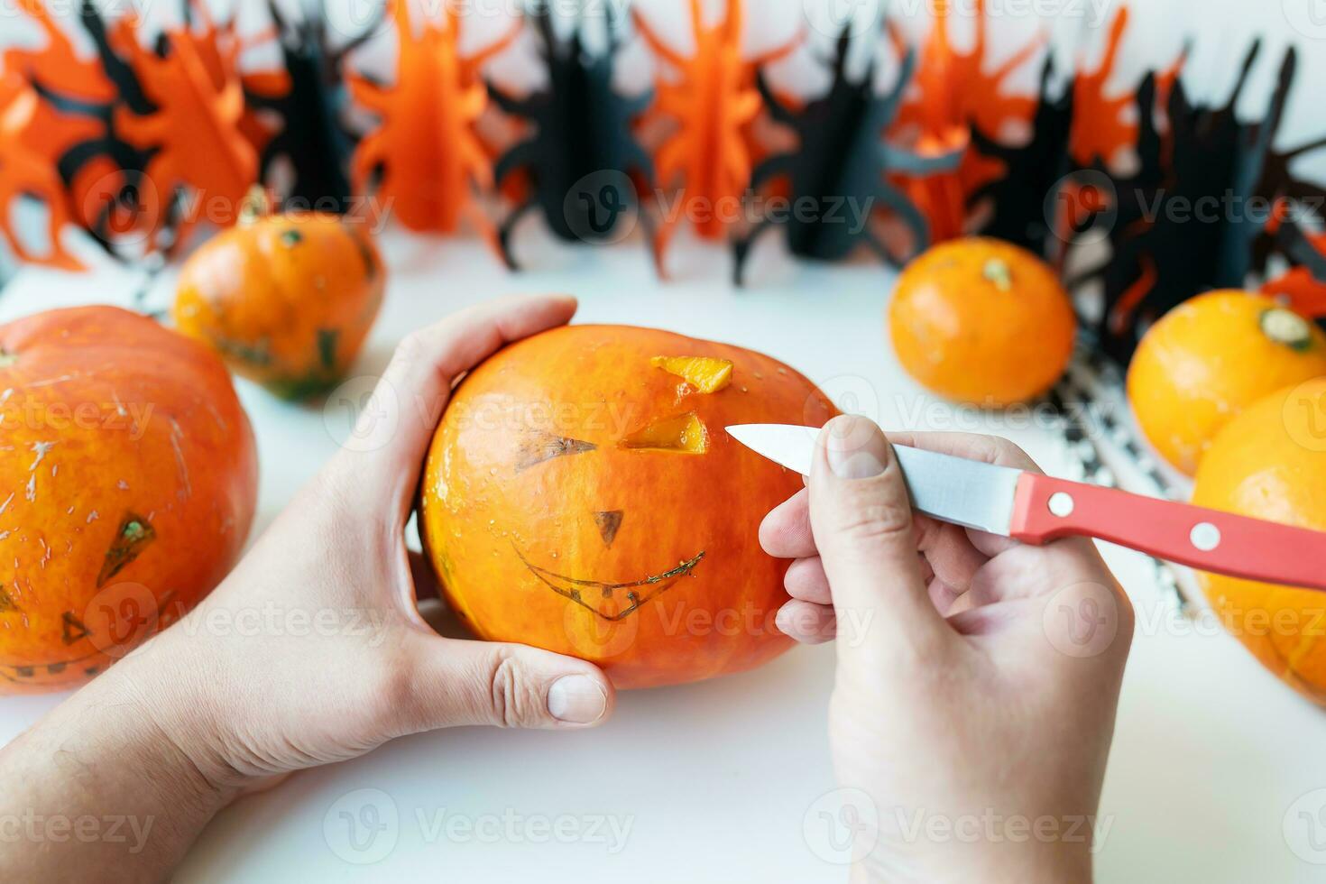 Halloween October 31st. A man cuts the face of a pumpkin with a knife. View from above. photo