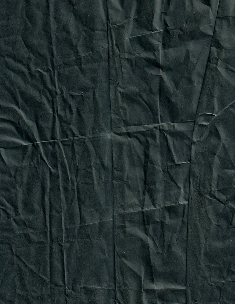 Creased black paper texture background. Crumpled and wrinkled grunge backdrop. photo