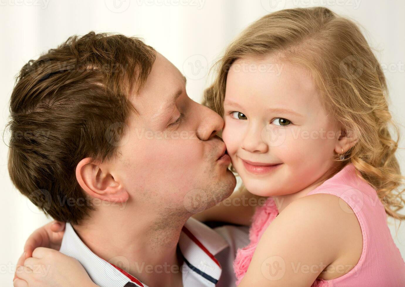 Daddy kissing beautiful little daughter photo