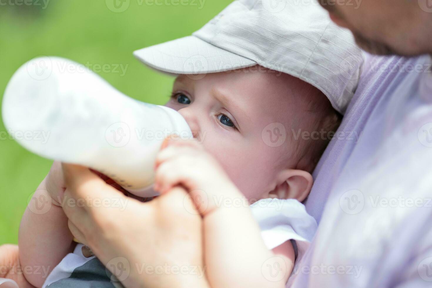 Man bottle feeding baby photo