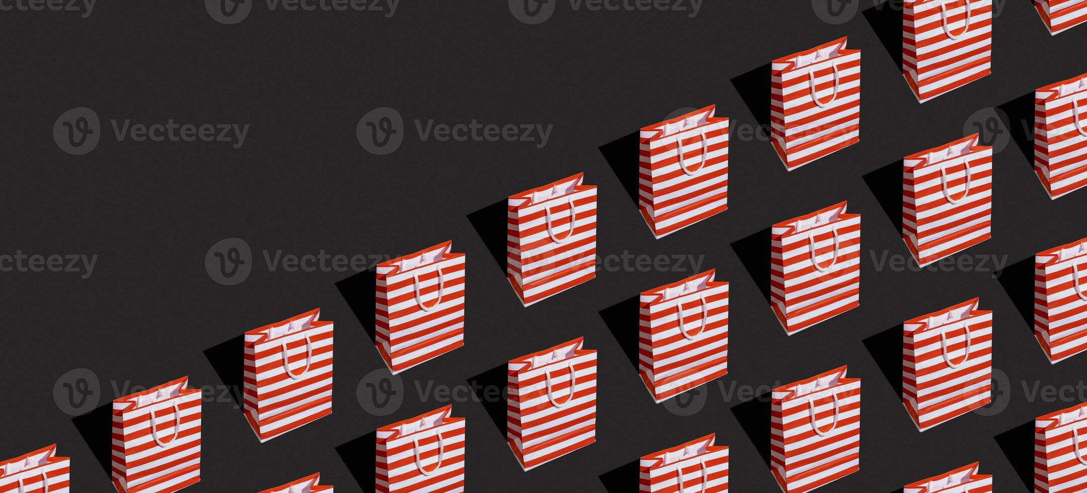 Pattern made from paper shopping bag on black background. Black friday sale, shopping concept. Banner with copy space. photo