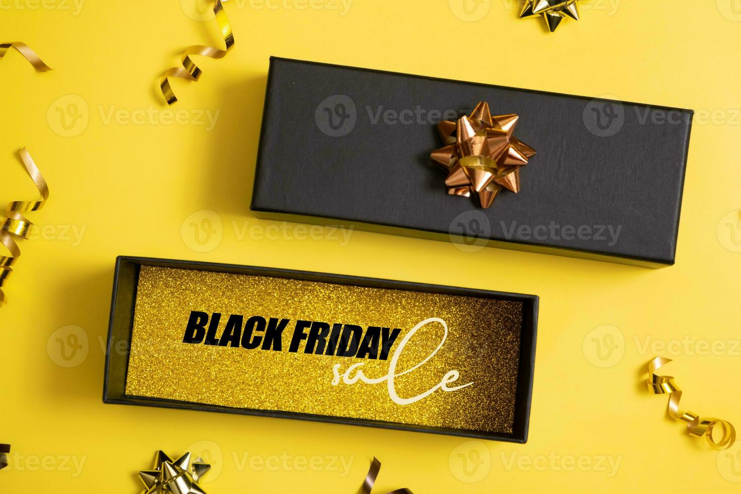 Black friday sale text in black gift box and festive decorations on yellow background flat lay, top view. photo