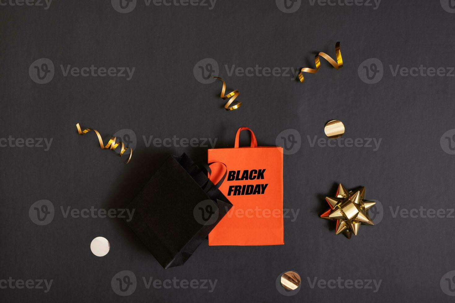 Black friday text, sale concept. Red and black paper shopping bags with decorations on black background. photo