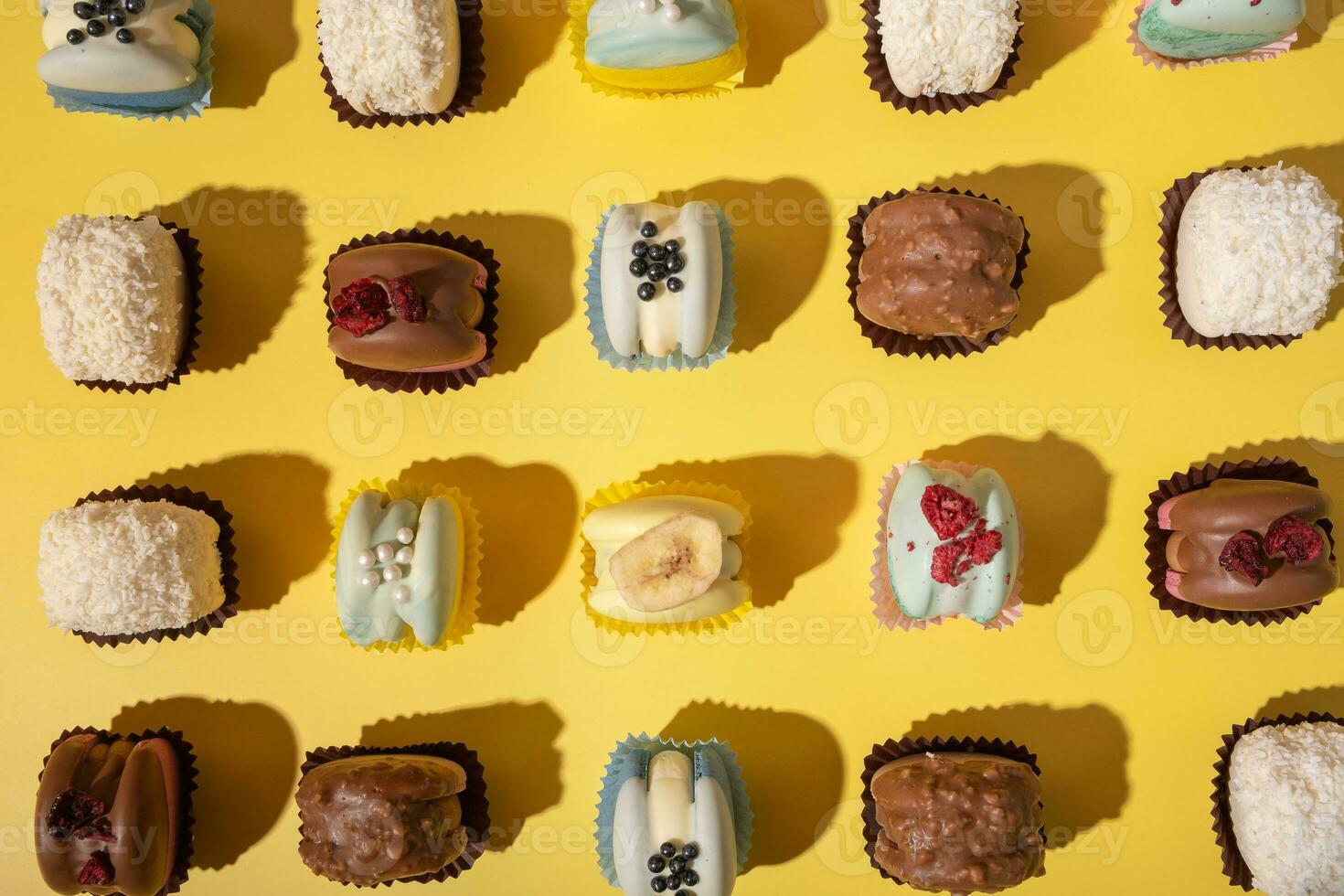 Set of different macaroons on yellow background top view, flat lay. Sweet wood pattern background. photo