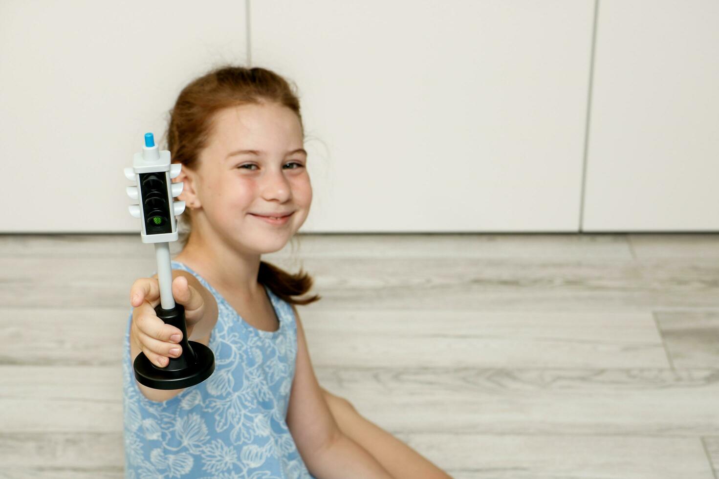 cute little girl holding out a toy traffic light with a green light photo