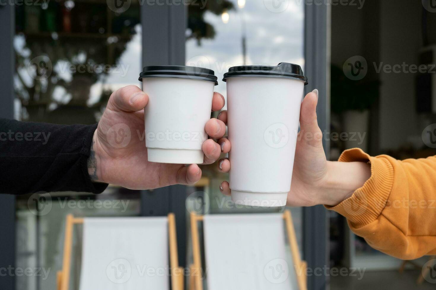 Two cardboard cups mock up in hands. Template for logo on drinks to go, takeaway photo