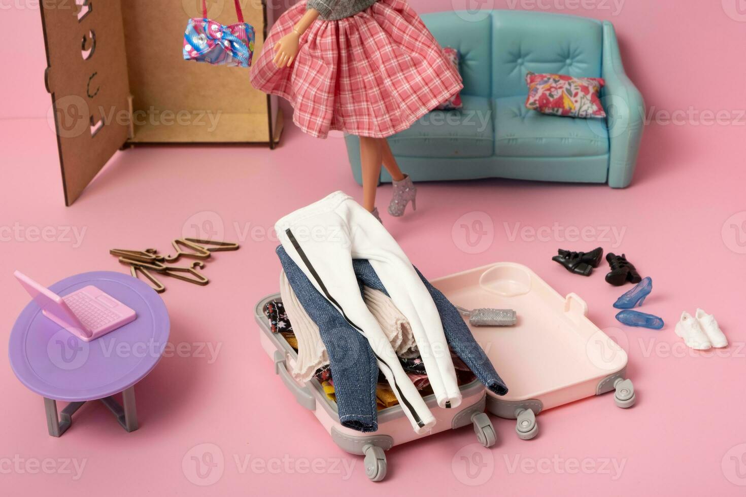 A lot of clothes in a suitcase. Travel and vacation concept. Doll's world. photo