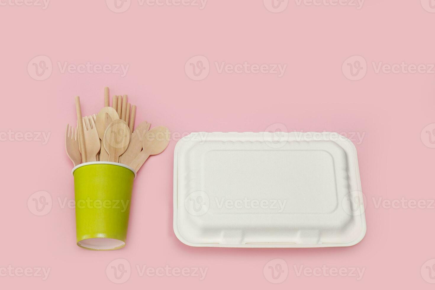 disposable wooden spoons, forks and knives in a paper cup with a corn raw lunchbox container photo