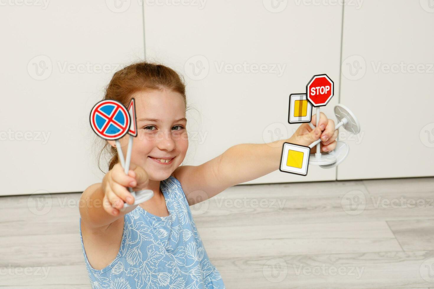 cute little girl holding toy road signs in her hands photo