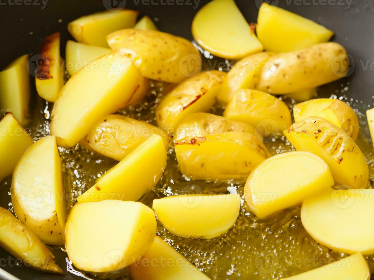fried potatoes with oil in frying pan photo