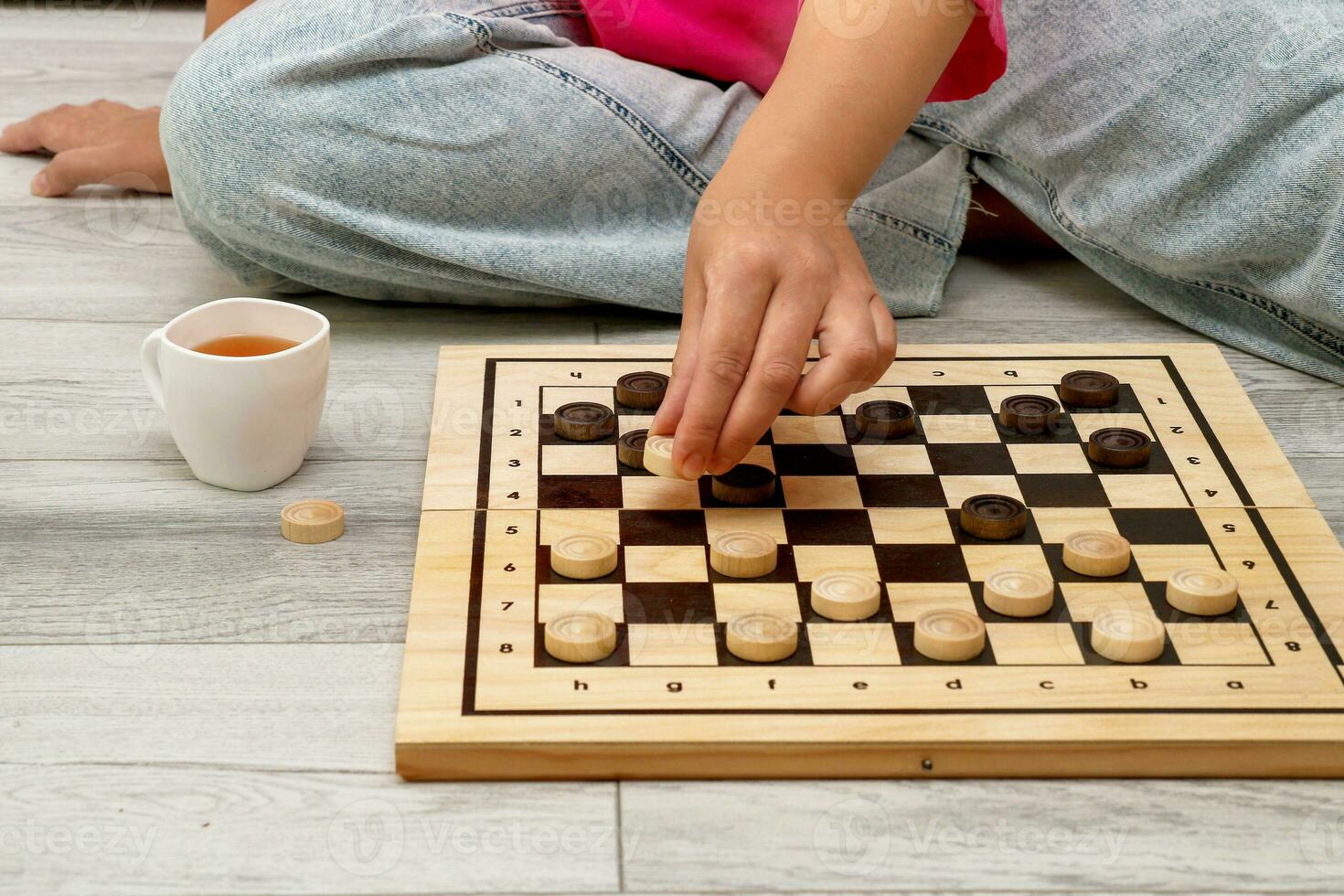 woman playing checkers at home sitting on the floor photo