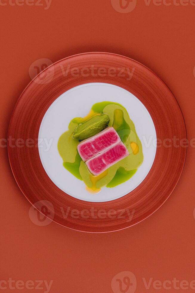 Tuna sashimi and pea puree on plate photo