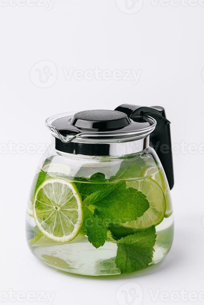 Fruit water with lime and mint in glass pitcher photo