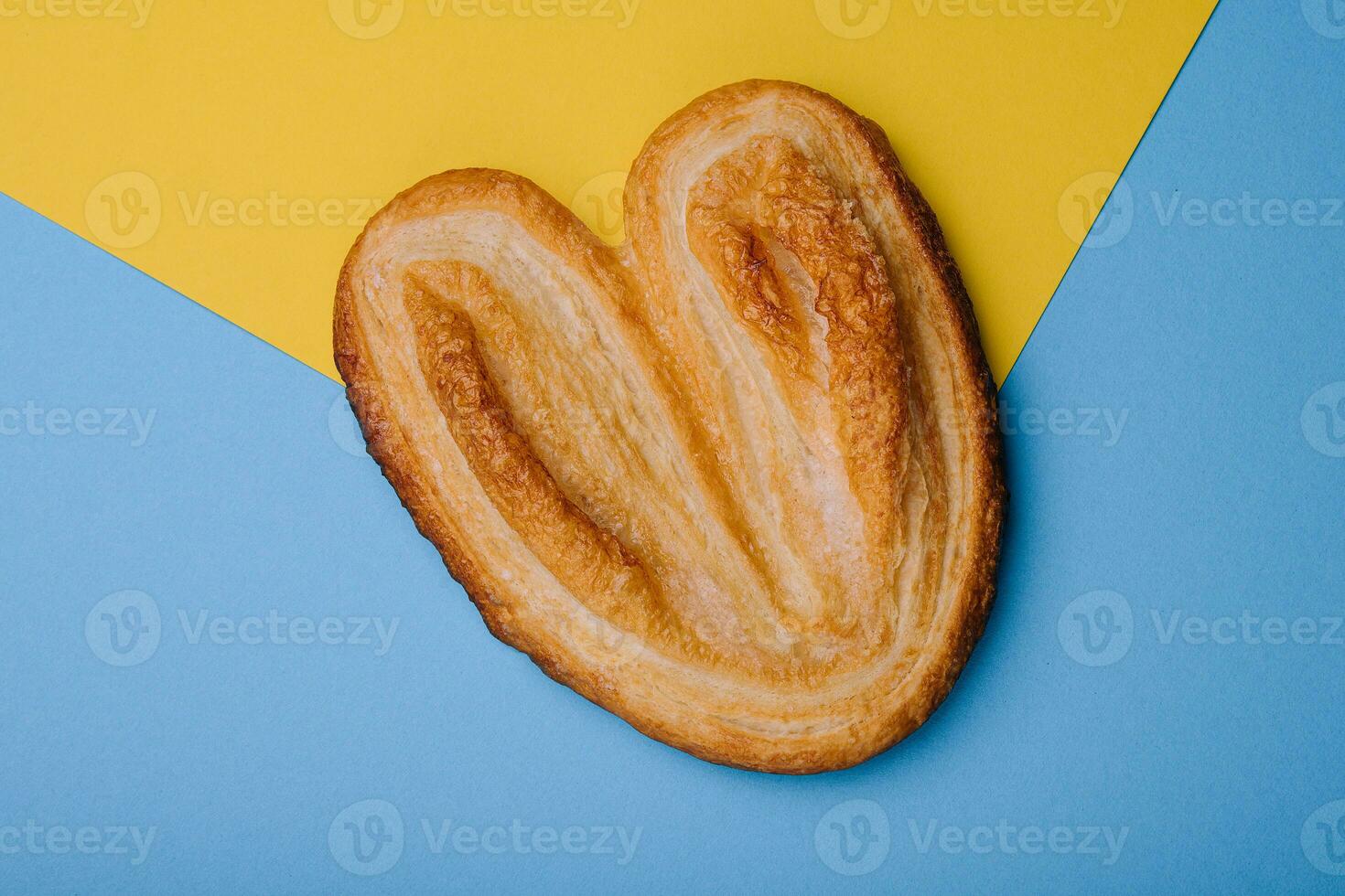 Puff pastry cookies on blue and yellow background photo