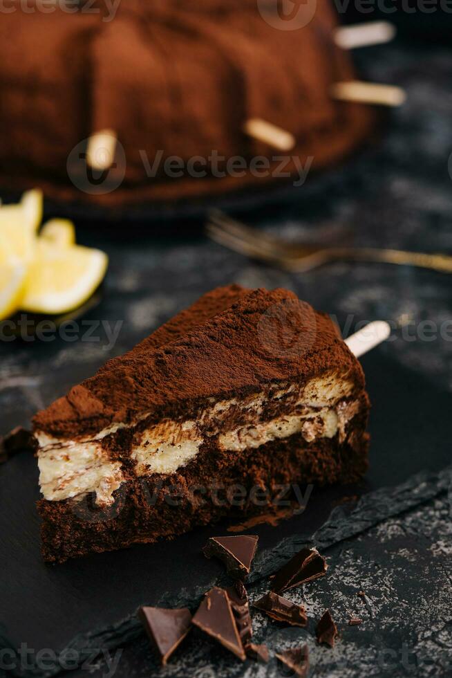 Composition with tiramisu, chocolate slices on black board photo