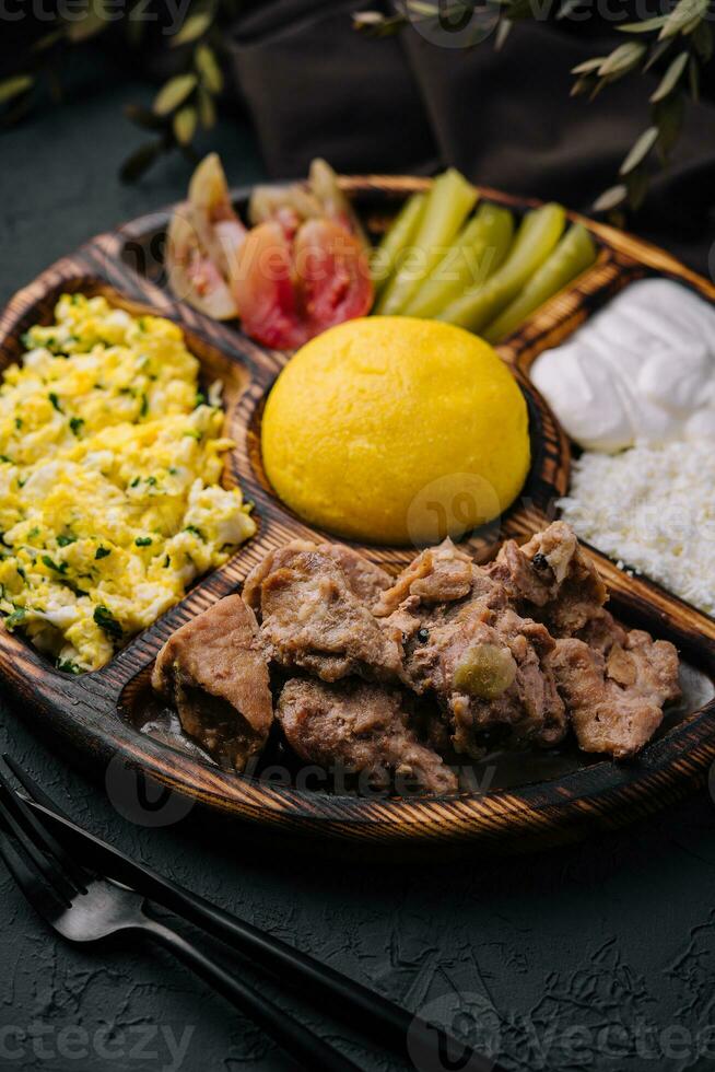 Traditional Moldavian hominy porridge on a wooden tray photo