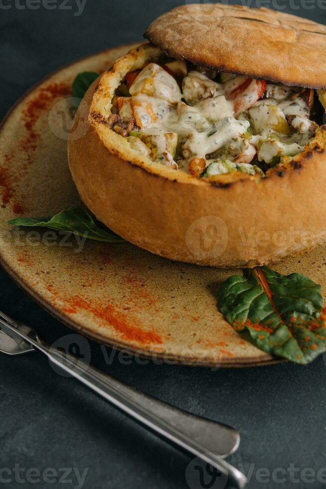 Pork medallions with mushroom sauce in bread pot photo