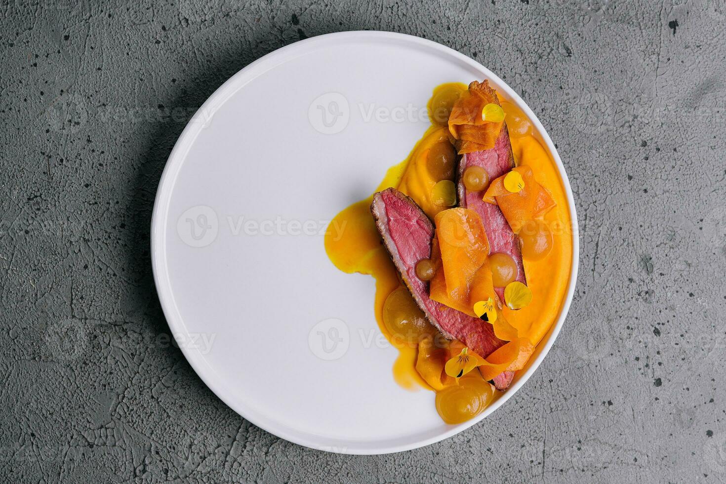 Exquisite serving juicy duck tenderloin with carrot puree photo