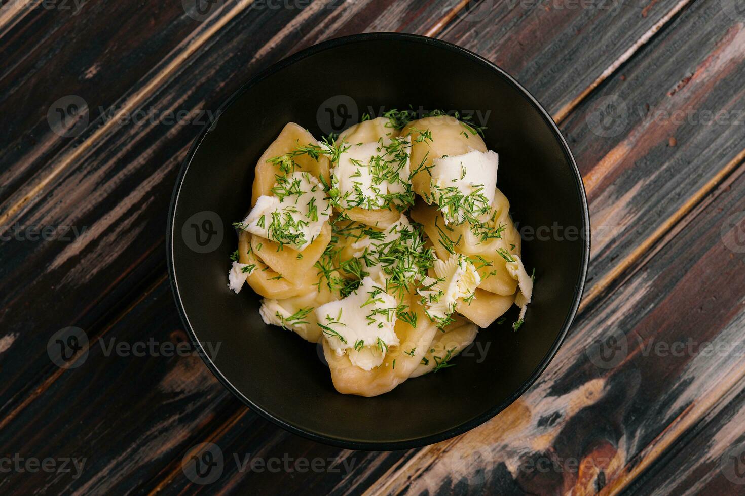 Plate of tasty cooked dumplings on black plate photo