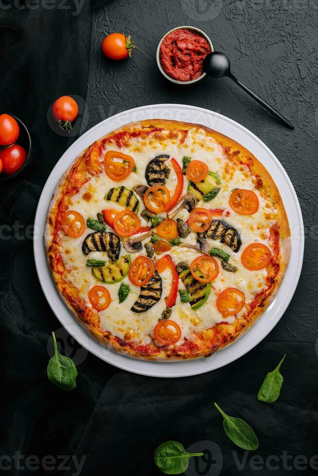 vegetarian pizza with zucchini, eggplant, mushrooms and tomato photo