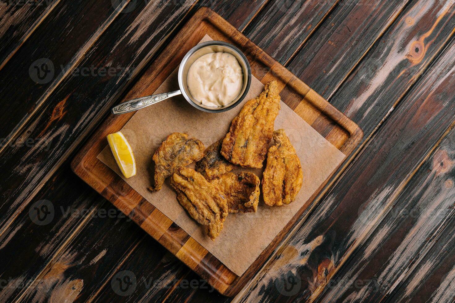 fried cod fillet pieces on wooden tray photo