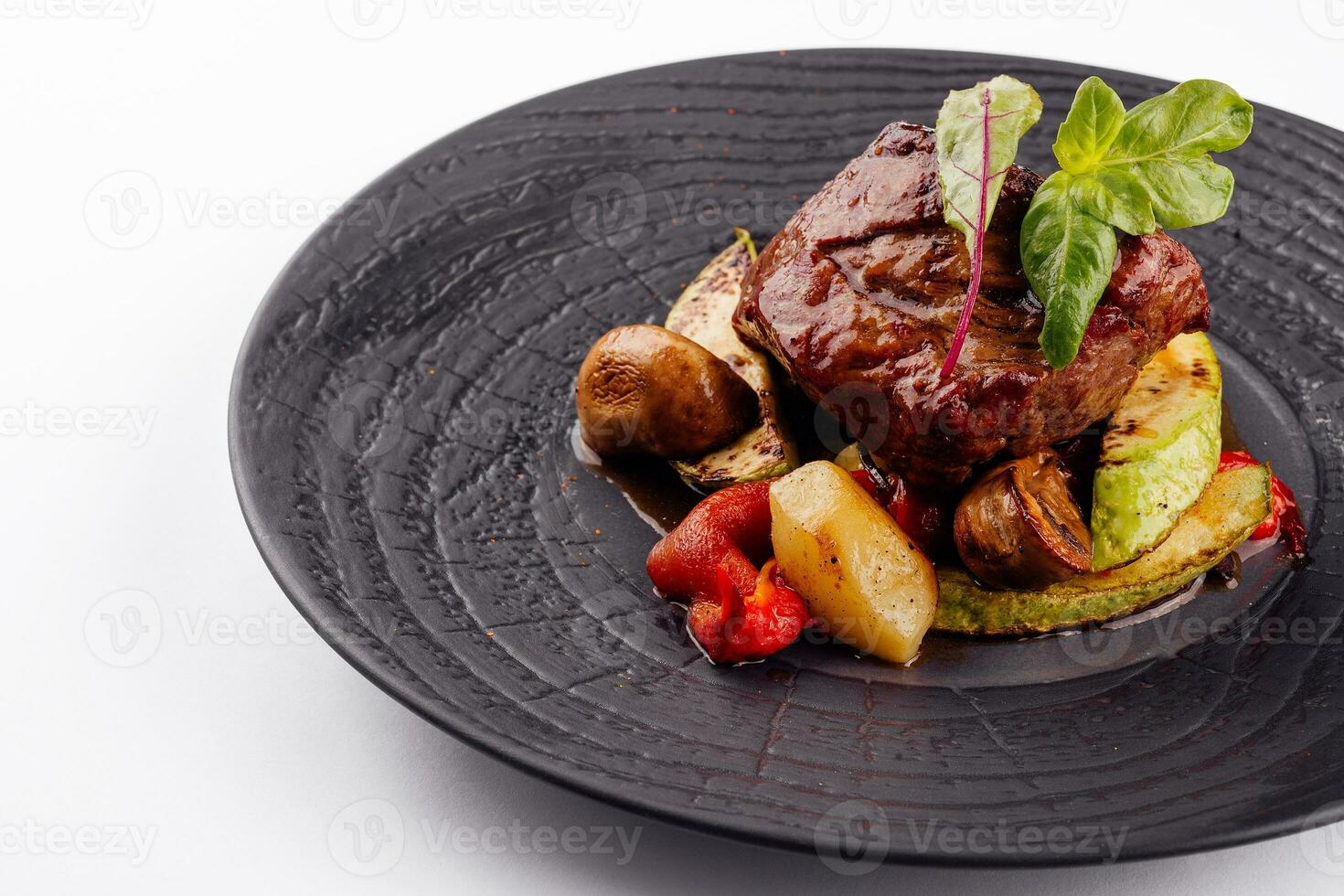 gourmet appetizing roasted beef steak with potato wedges and other vegetables photo