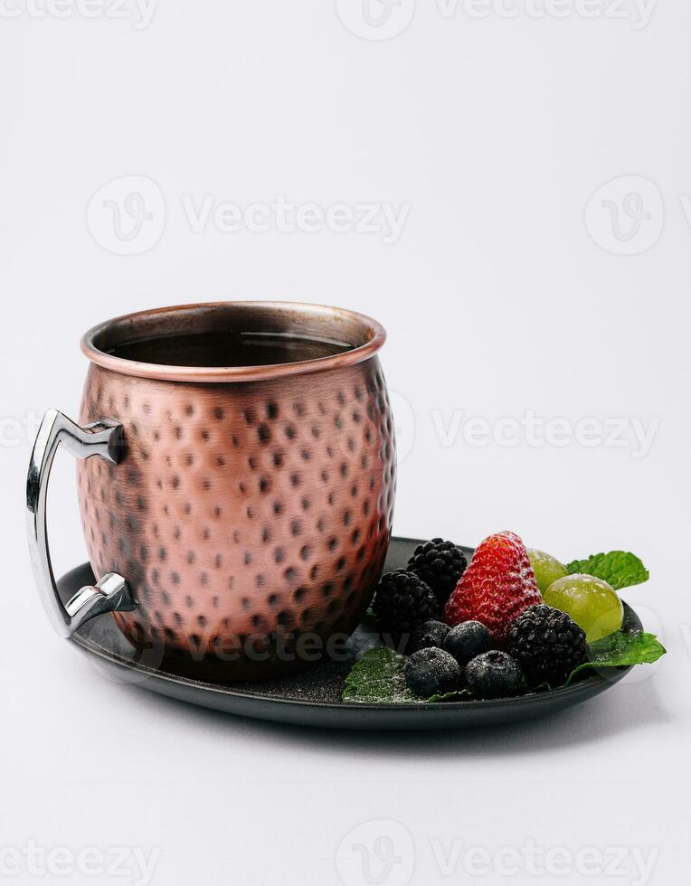 metal camp mug with tea with berries photo