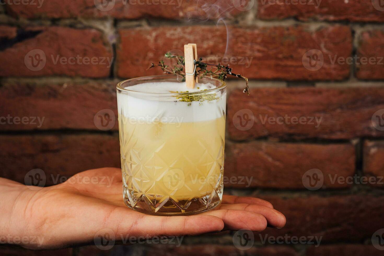 Delicious light yellow sour foam cocktail in the etched glass photo