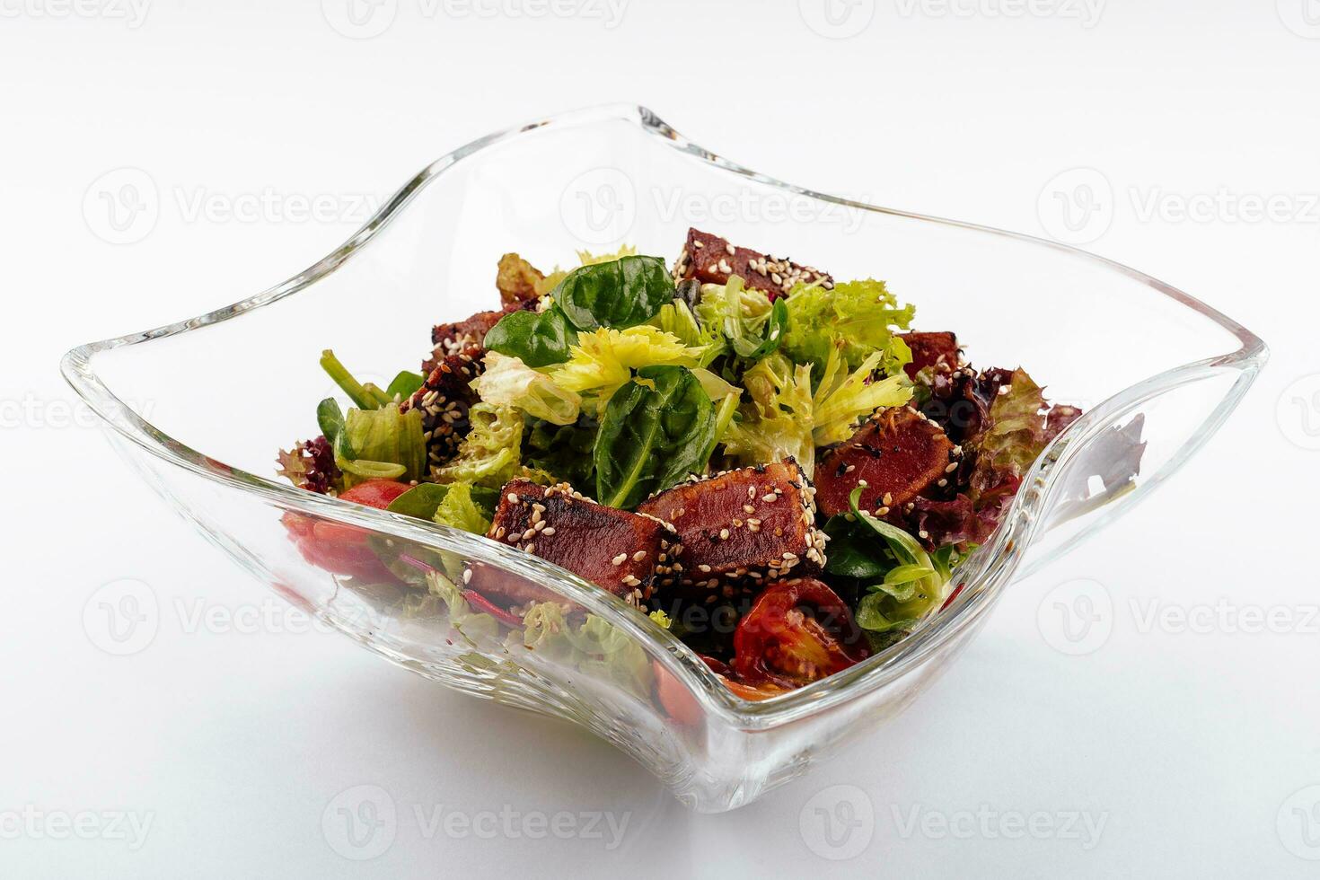 Salad with fried tuna on glass plate photo