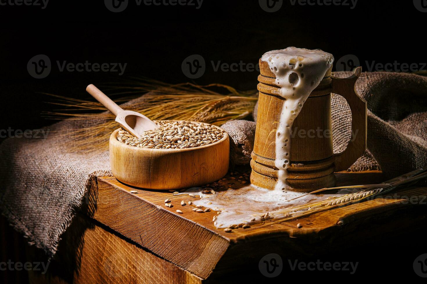 Wooden beer mug with beer and foam standing on a wooden table photo
