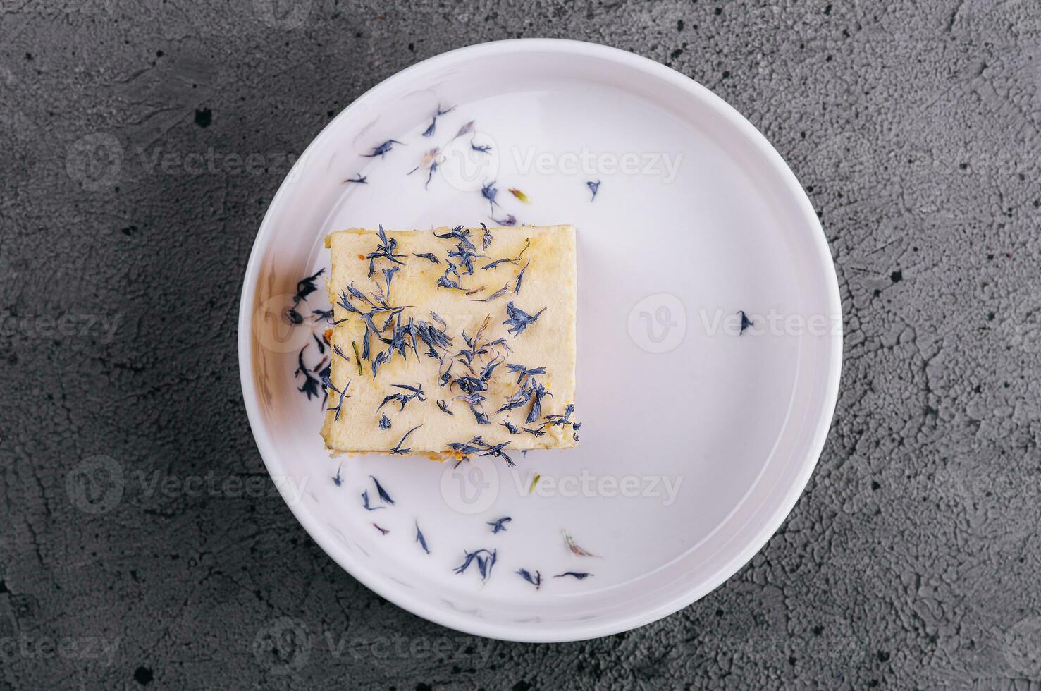 French mille feuille cake with vanilla cream decorated with blue flower leaves photo