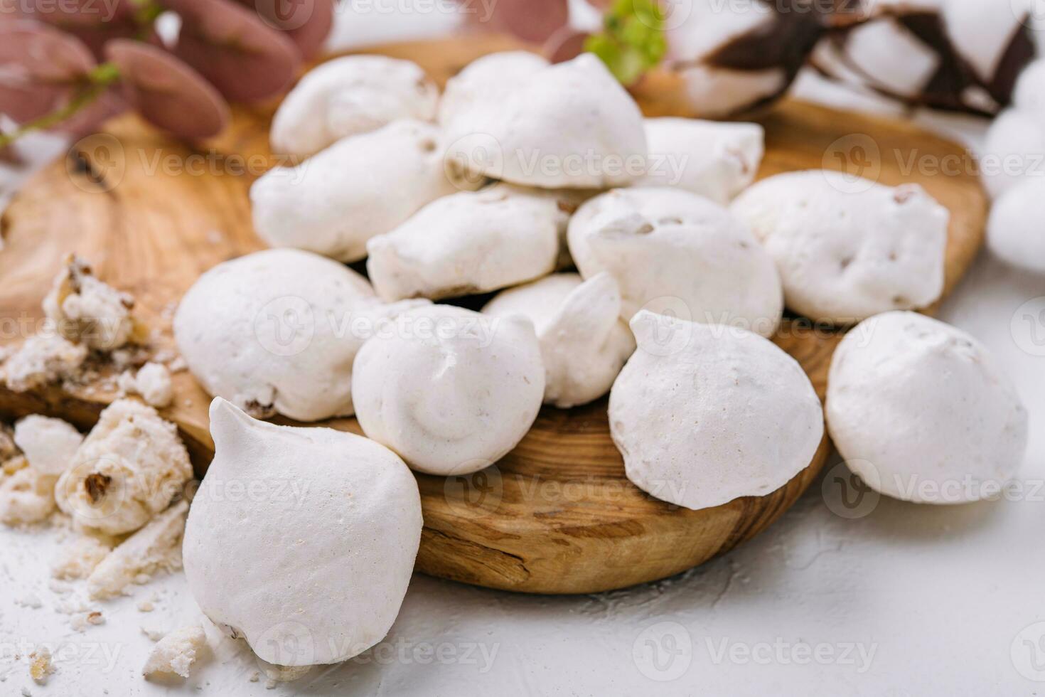 Fresh meringue cookies on wooden board photo