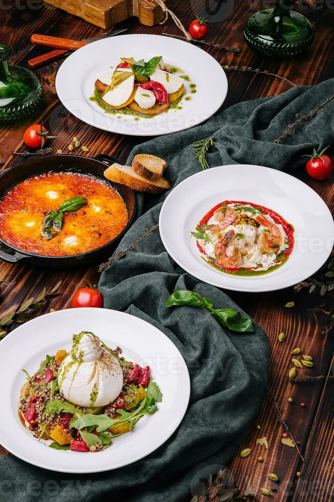 different types of italian dishes on a large wooden table photo