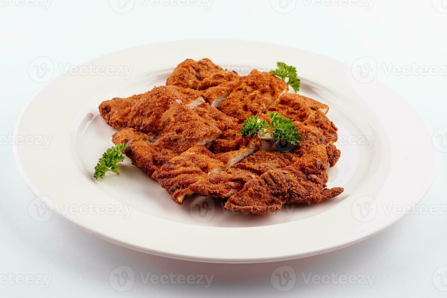 Chicken schnitzel sliced on white plate photo