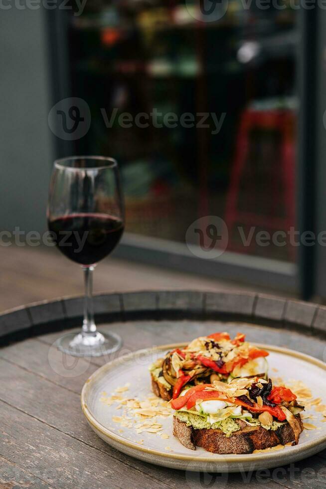 Vegetable stew with eggplant, red bell pepper and tomatoes on toasted rye bread photo