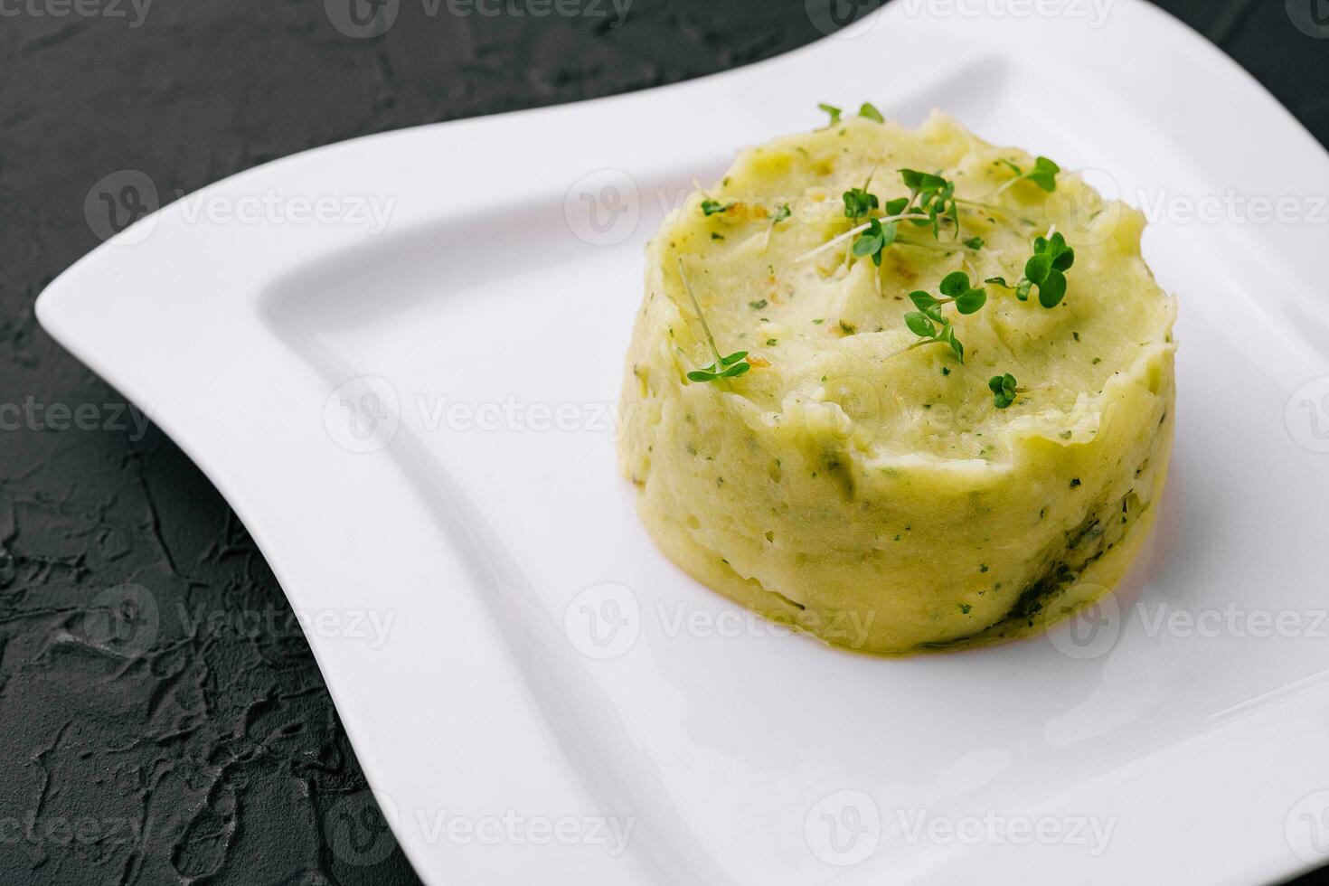 Mashed potatoes with pesto on white plate photo