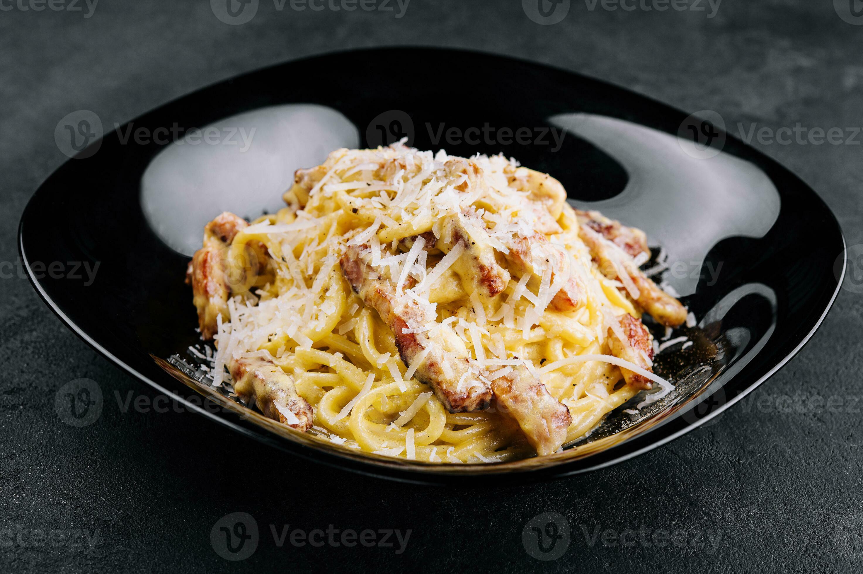 Spagetti carbonara on a black plate 30516893 Stock Photo at Vecteezy