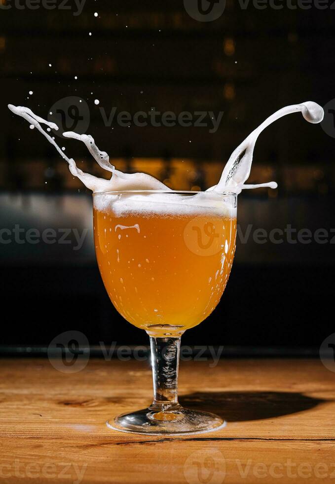 Glass of splashing beer close up photo