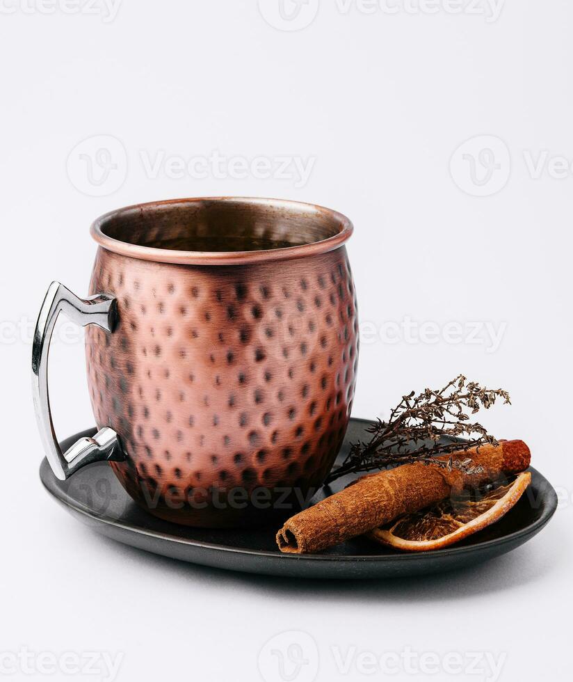 Mulled wine in vintage metal mug with cinnamon photo